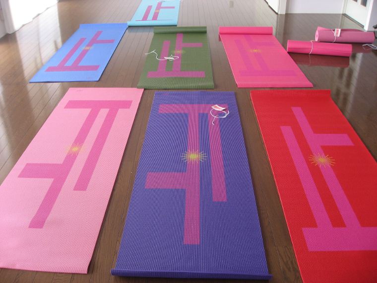 Colourful yoga mats laid out on a wooden floor